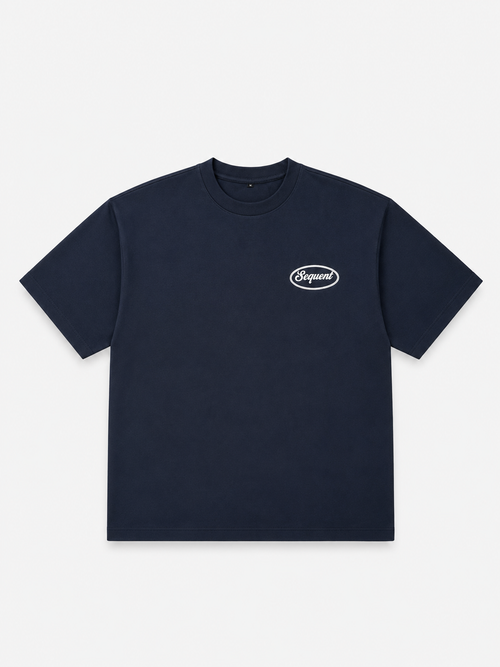 A navy blue short-sleeve crewneck t-shirt with a small white oval 'Sequent' logo on the left chest, displayed flat against a light gray background.