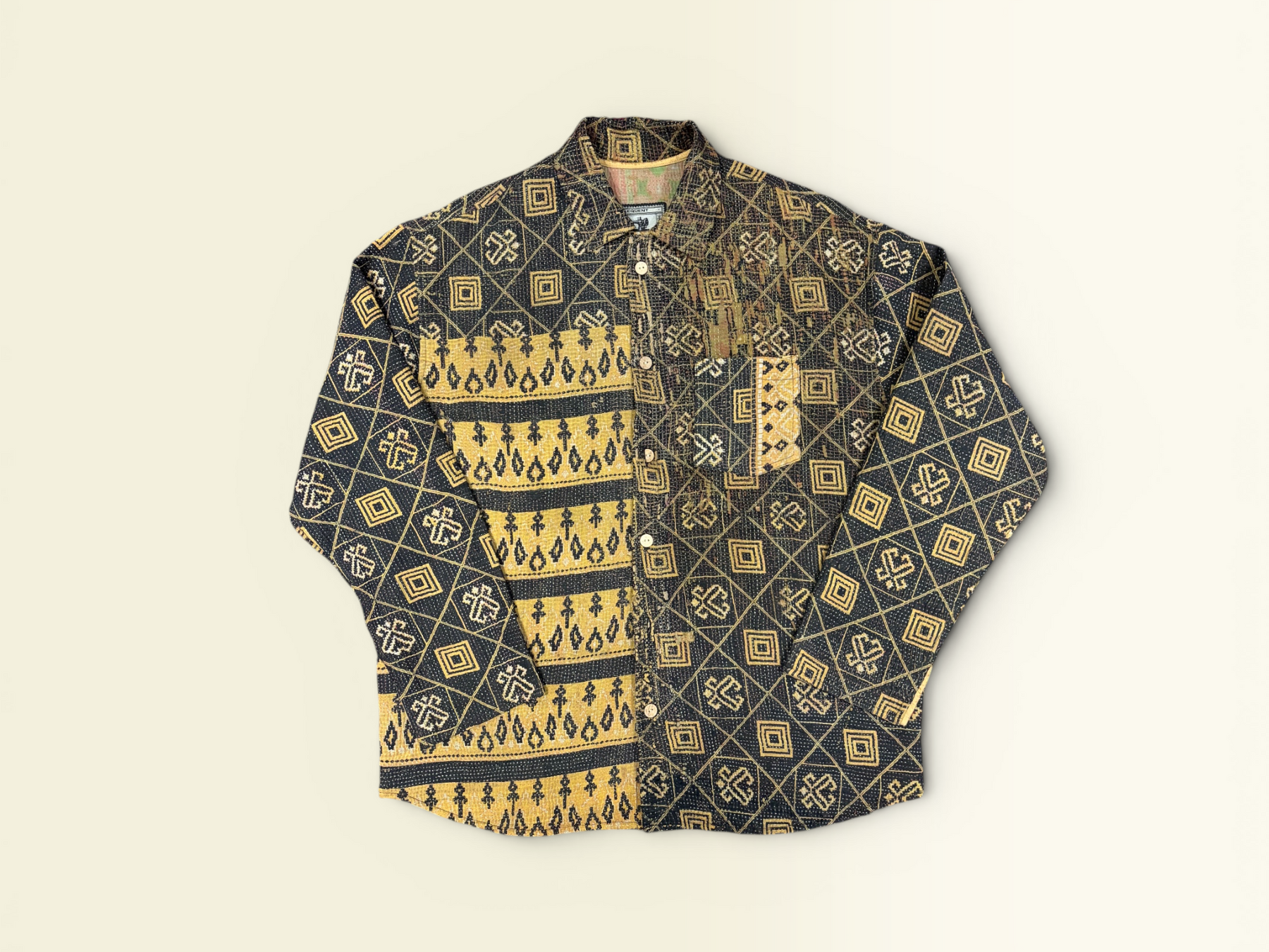A long-sleeve button-up vintage Kantha shirt with a dark charcoal base and a yellow geometric pattern, laid flat against a light cream background.