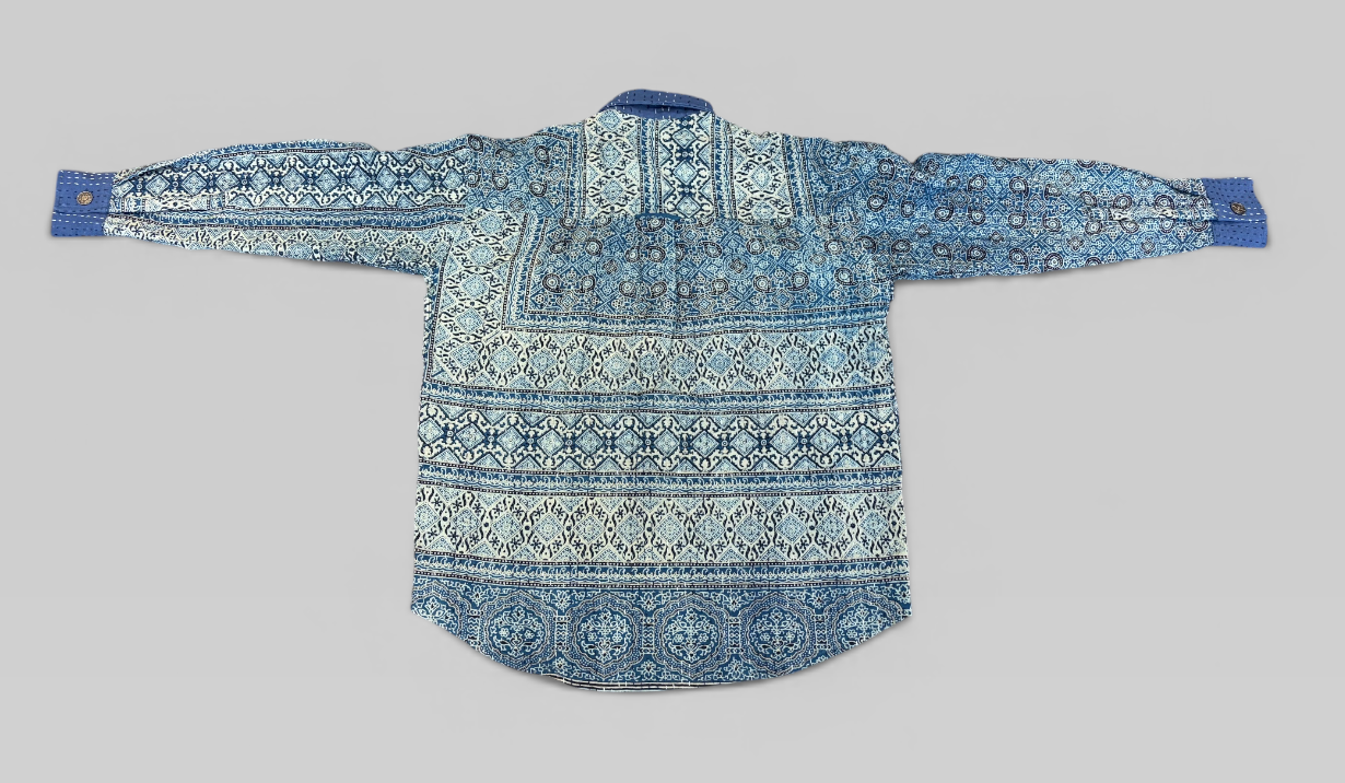 Blue and white hand painted Ajrakh Kantha shirt on a gray background