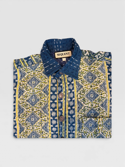 Blue and yellow patterned Ajrakh Kantha shirt with 'Sequent' label on a light gray background