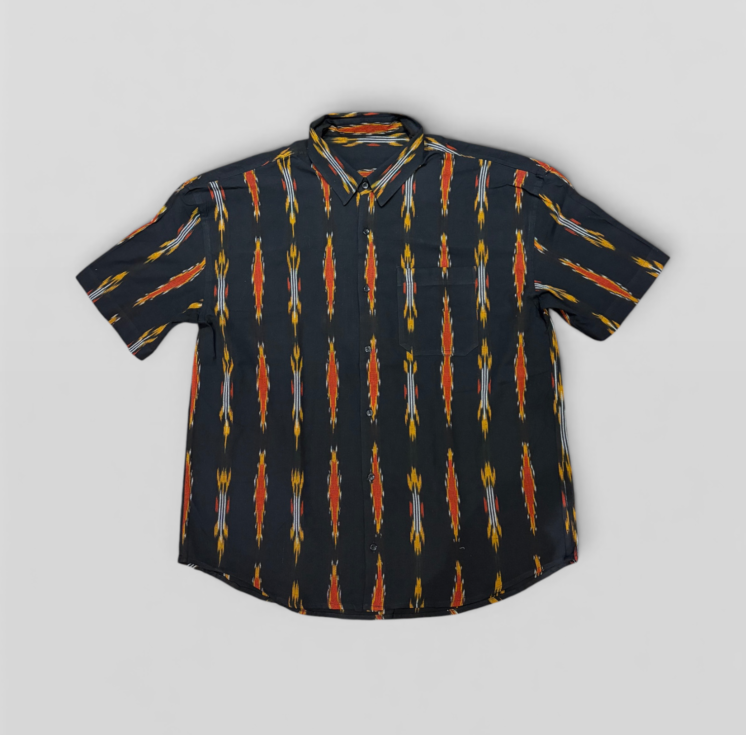 Black button down half-sleeve handwoven Ikat Shirt with colorful pattern on a gray background